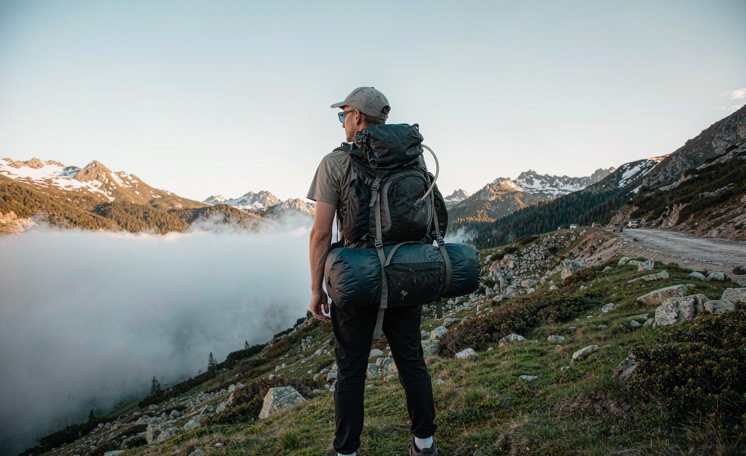 Hiker on a mountain trail wearing a modular hiking backpack with hip belt pouches