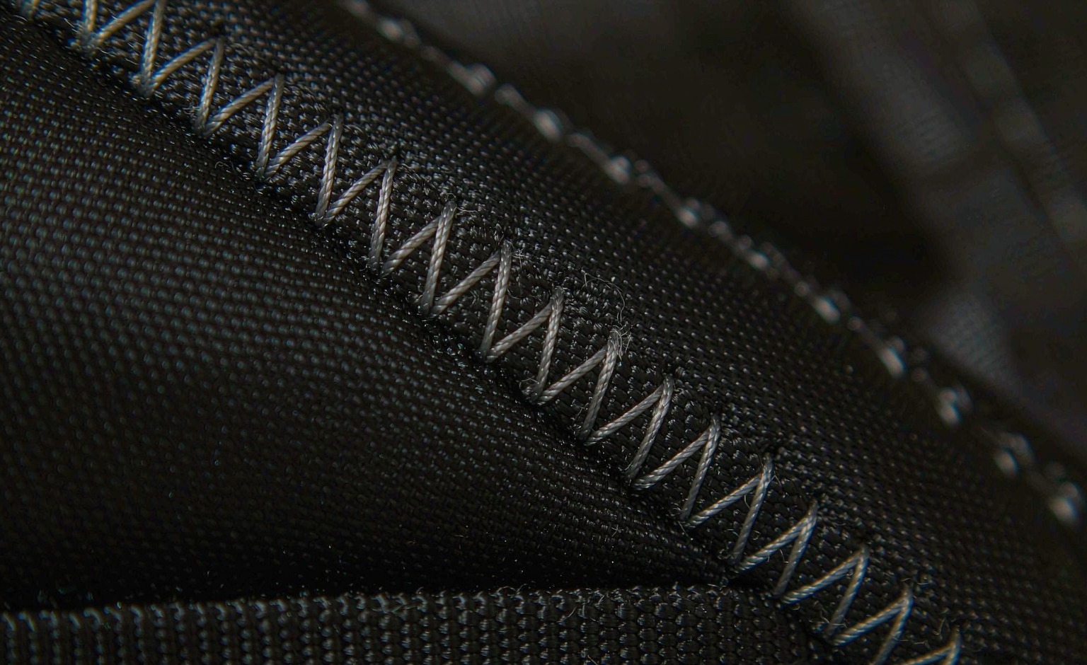Macro view of lockstitch seam density and bar-tack reinforcement on coated nylon