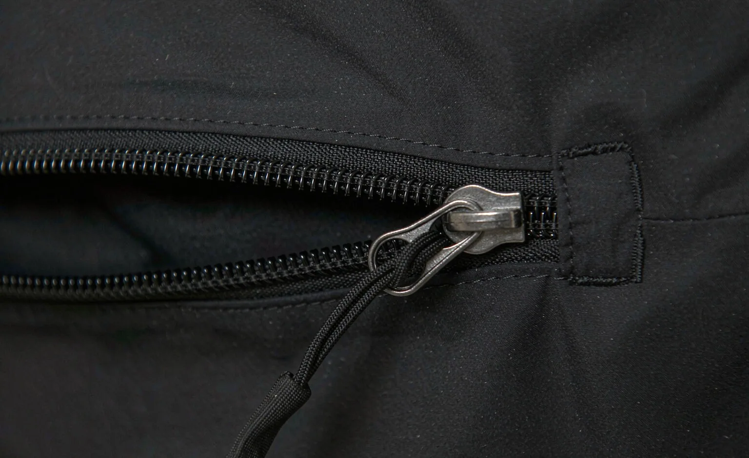 Close-up of a coil zipper and attachment webbing on a modular panel