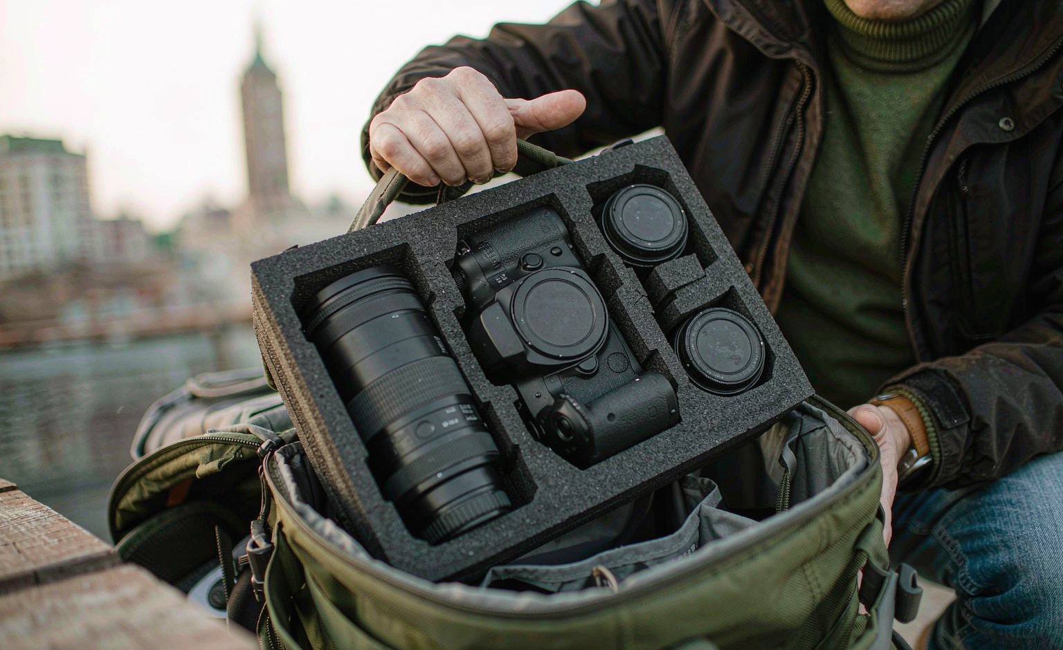 Photographer opening a modular camera insert pulled from a modular backpack
